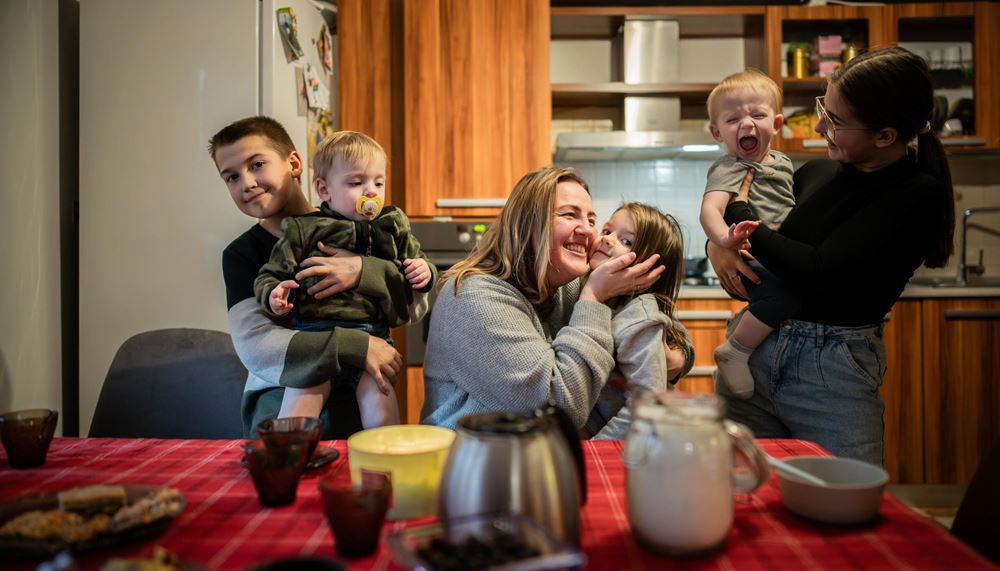 Mutter mit ihren fünf Kindern in der Wohnung am Küchentisch (Foto: Jakob Studnar / Kindernothilfe)