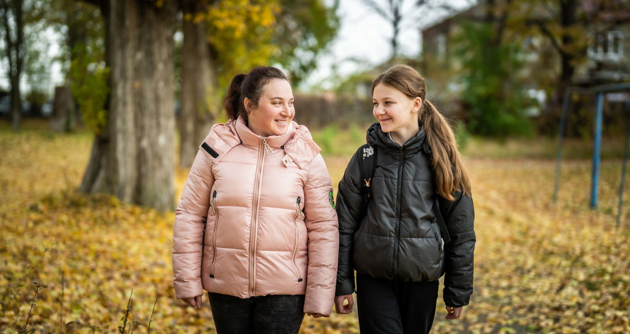 Mutter und Tochter lächeln sich auf einem Spaziergang an (Foto: Jakob Studnar / Kindernothilfe)