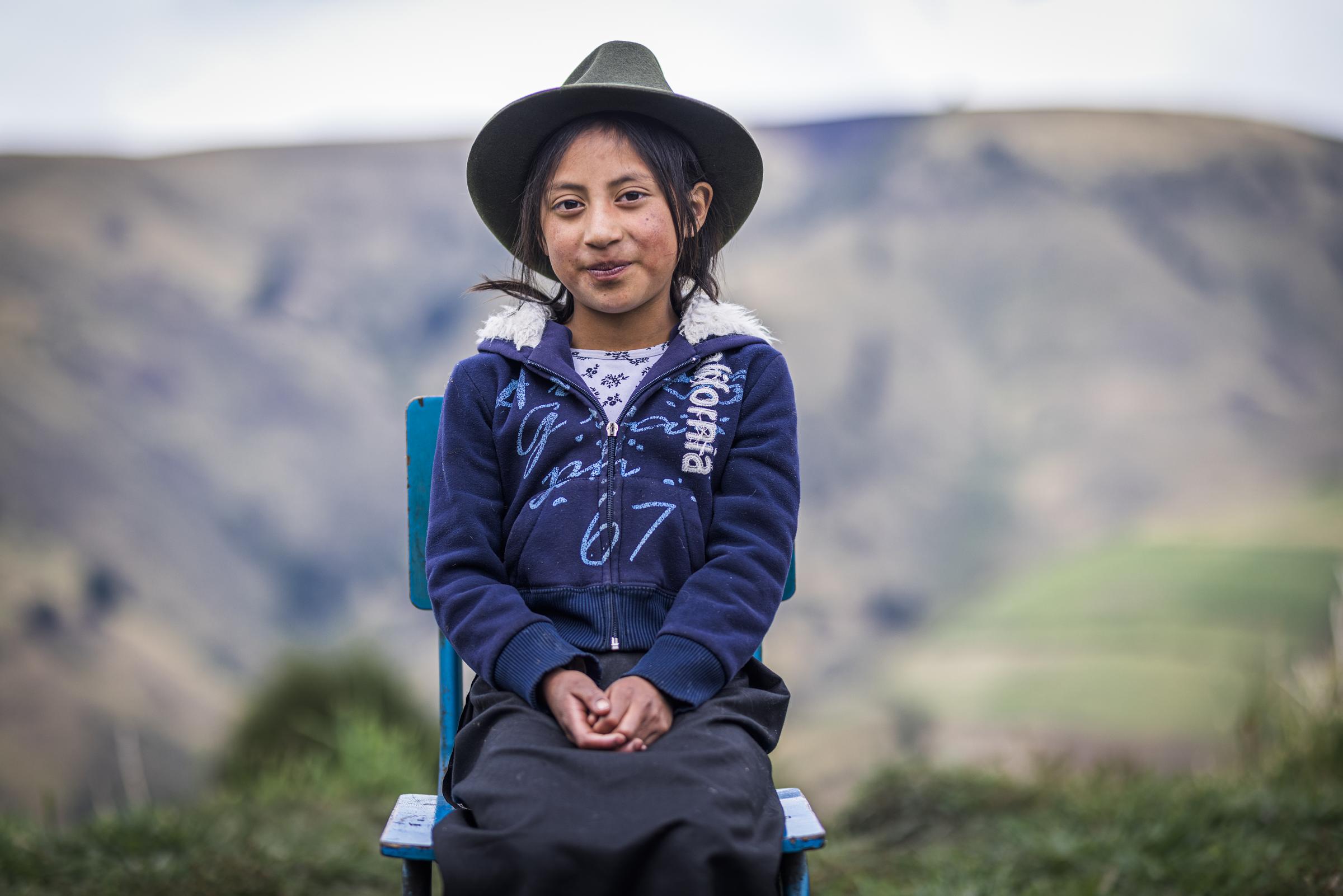 Ein Mädchen aus Ecuador sitzt auf einem Stuhl. (Quelle: Martin Bondzio)