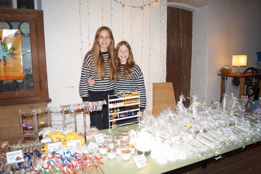 Zwei Mädchen Arm in Arm hinter einem Verkaufstisch (Quelle: privat)