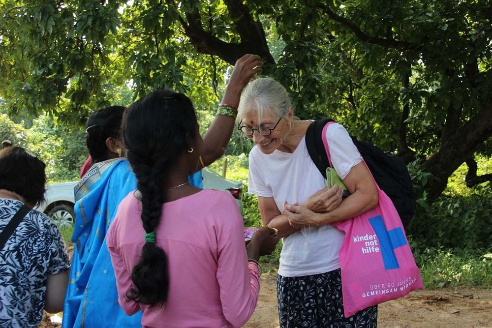 Eine Frau mit einem Kindernothilfe-Beutel unterhält sich mit einer Inderin (Quelle: privat)