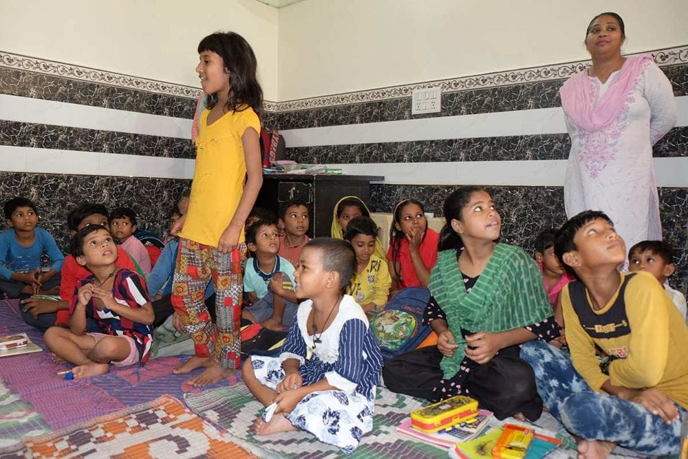 Eine Kindergruppe sitzt auf dem Boden, ein Mädchen steht (Quelle: privat) Eine Kindergruppe sitzt auf dem Boden, ein Mädchen steht (Quelle: privat)