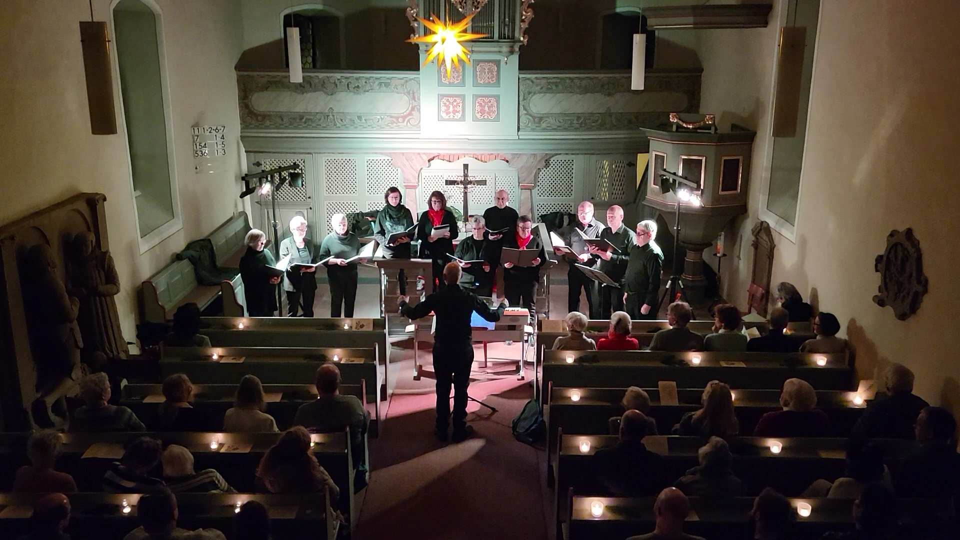 In einer weihnachtlich geschmückten Kirche singt vor dem Altar ein Chor (Quelle: privat)