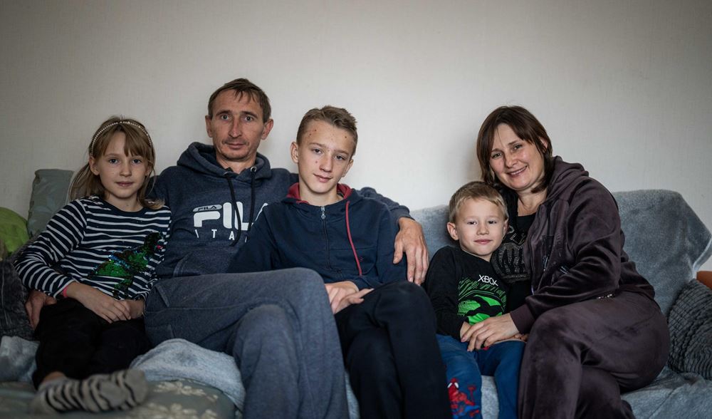 Eine Ehepaar mit drei Kindern sitzt auf einem Sofa (Quelle: Jakob Studnar/Kindernothilfe)