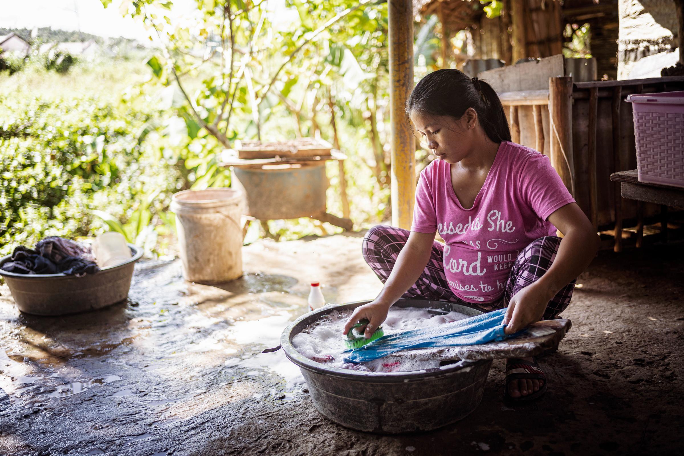 Ein schwangeres Mädchen sitzt auf dem Boden und wäscht Wäsche in einer Schüssel (Quelle: Jakob Studnar) Ein schwangeres Mädchen sitzt auf dem Boden und wäscht Wäsche in einer Schüssel (Quelle: Jakob Studnar)