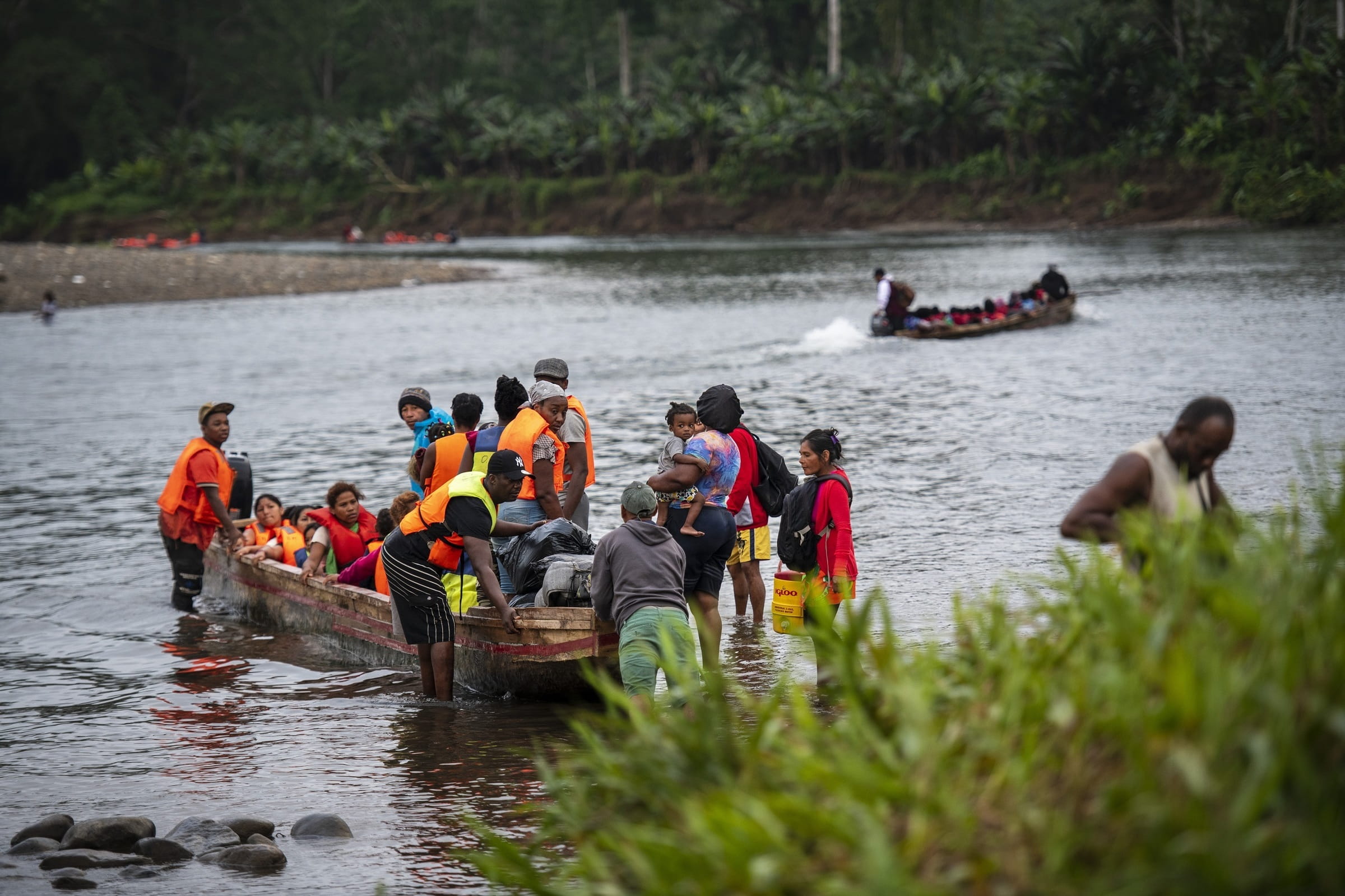 Viele Leute sitzen in einem Boot auf einem Fluss, andere stehen drum herum (Quelle: Florian Kopp)