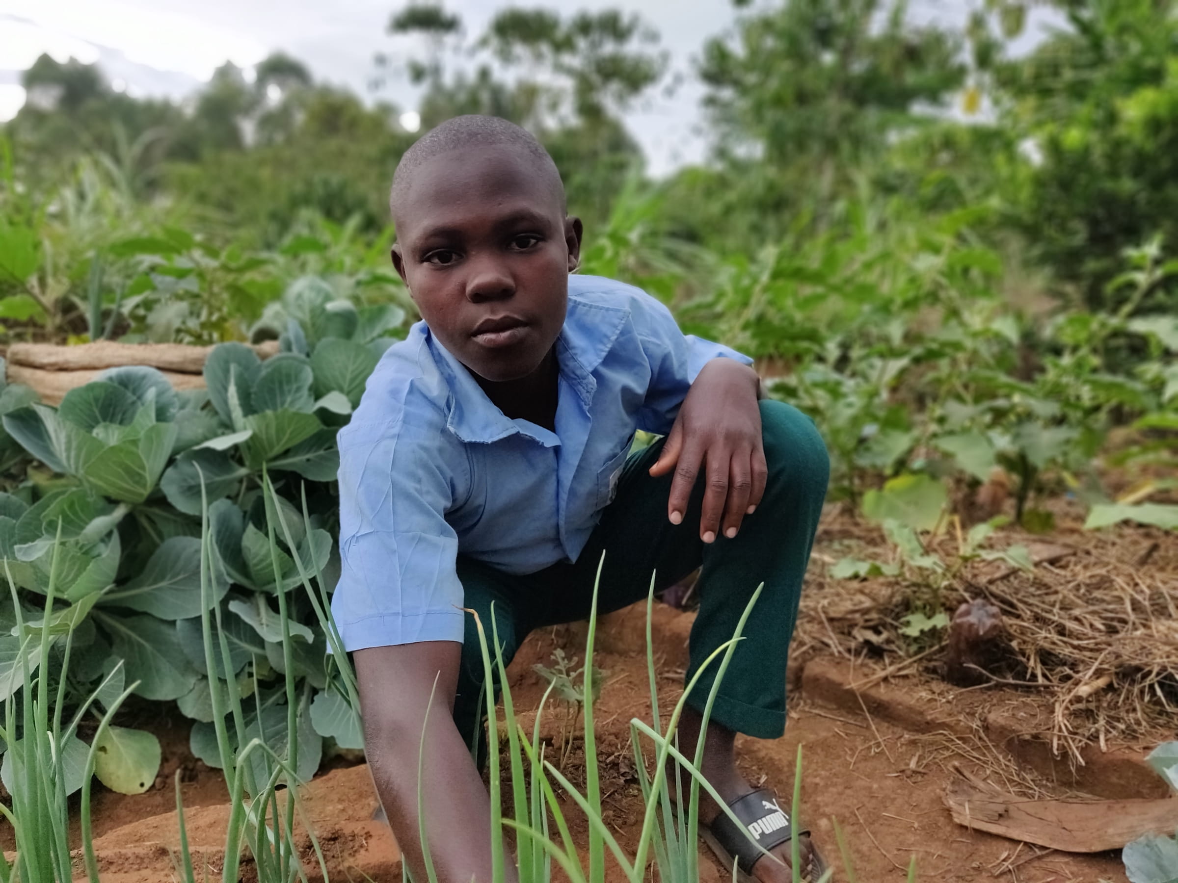 Junge aus Uganda in seinem Garten. (Quelle: Katharina Drzisga)