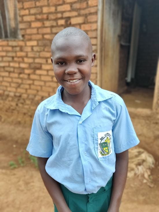 Ein Farmschüler aus Uganda vor seinem Haus. (Quelle: Katharina Drzisga)