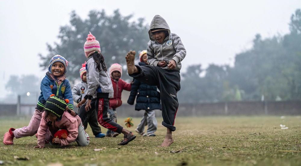 Kinder in Nepal toben auf einer Wiese. (Quelle: Jakob Stundar) Platzhalterbild