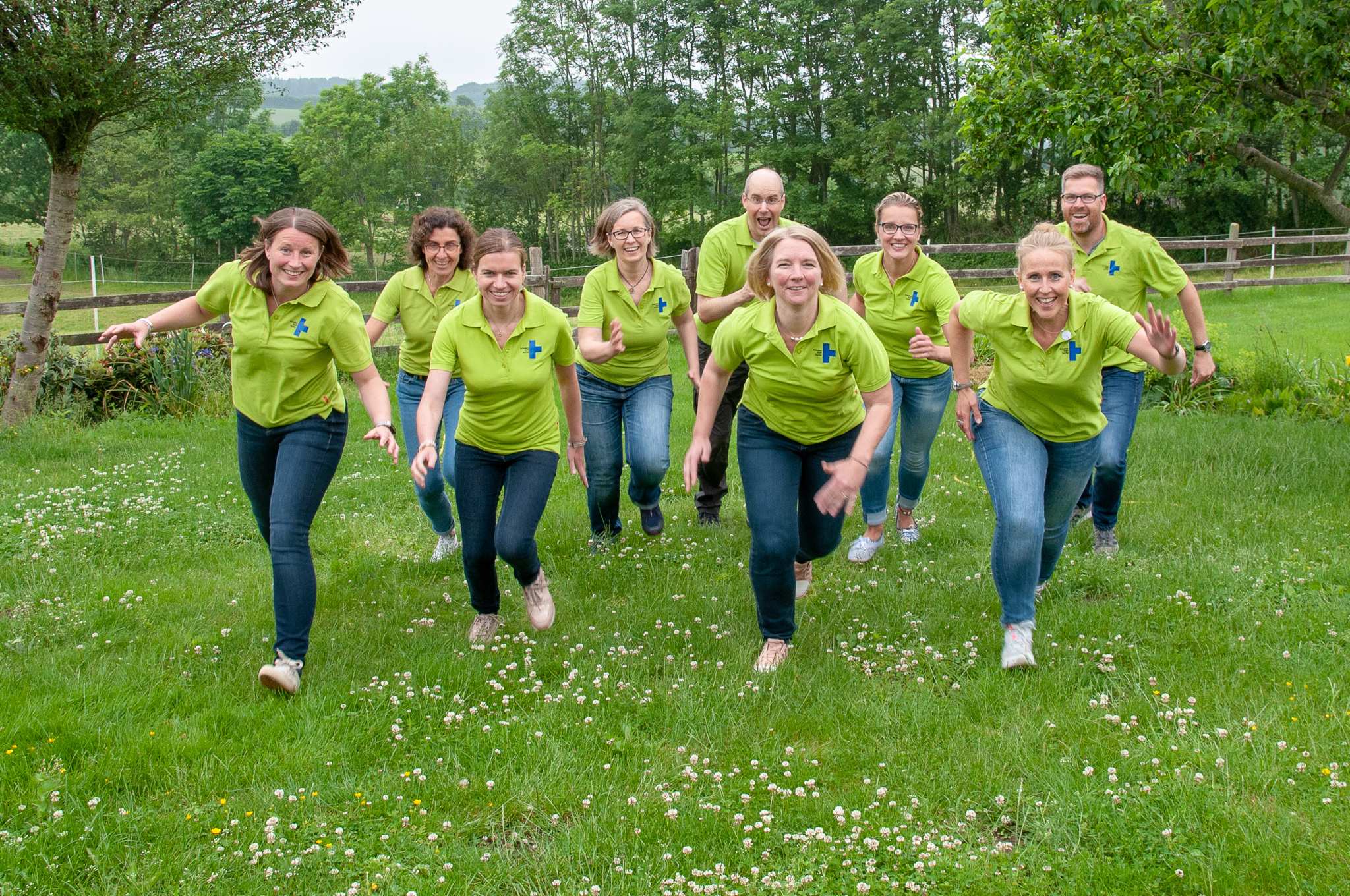 Männer und Frauen in grünen T-Shirts laufen über eine Wiese auf den Fotografen zu (Quelle: privat)