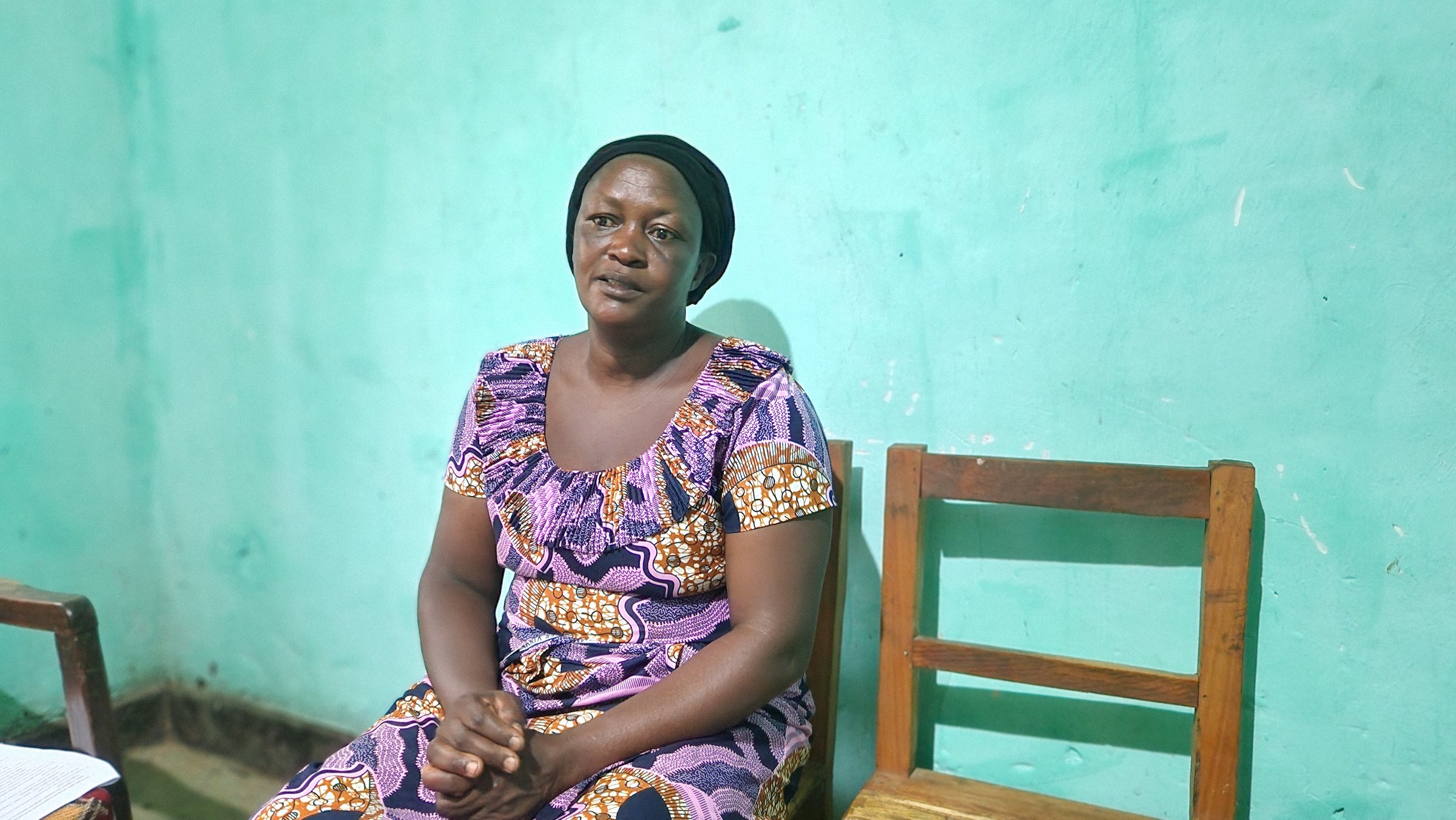 Eine Frau sitzt vor einer türkisfarbenen Wand auf einem Stuhl (Quelle: Jessica Jung)