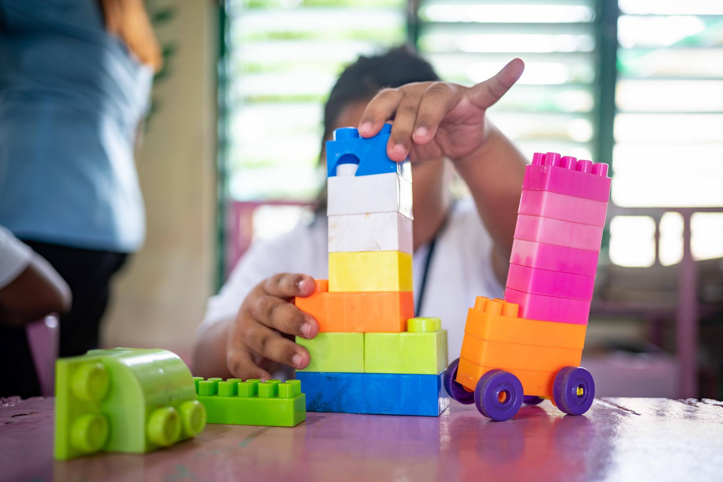 Ein Kind spielt mit bunten Bauklötzchen und stapelt sie aufeinander (Foto: Jakob Studnar) Ein Kind spielt mit bunten Bauklötzchen und stapelt sie aufeinander (Foto: Jakob Studnar)