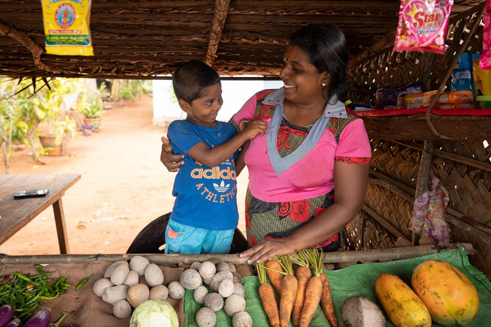Eine Frau mit ihrem Sohn in ihrem Geschäft hinter der Gemüseauslage (Quelle: Christian Nusch)