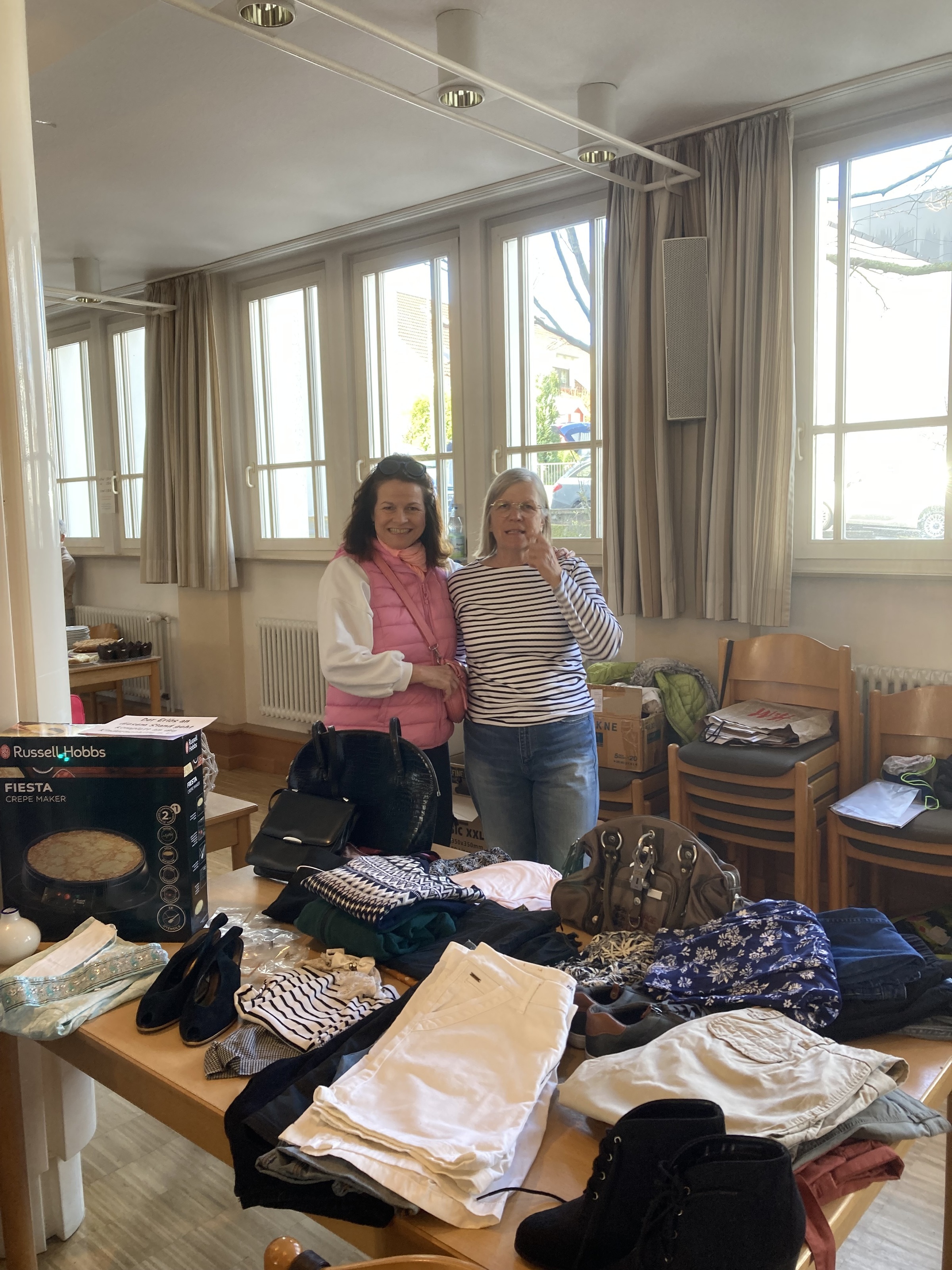 Zwei Frauen stehen hinter einem Verkaufstisch mit Kleidung (Quelle: privat) Zwei Frauen stehen hinter einem Verkaufstisch mit Kleidung (Quelle: privat)