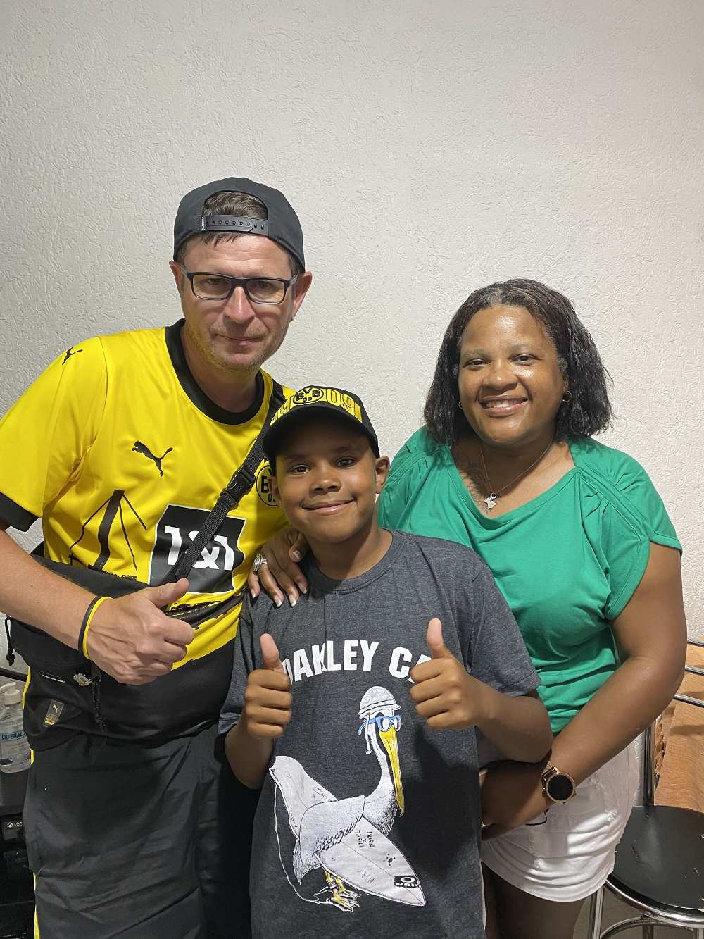 Ein Ehepaar mit seinem Patenkind, der Junge trägt eine BVB-Kappe (Quelle: privat) Ein Ehepaar mit seinem Patenkind, der Junge trägt eine BVB-Kappe (Quelle: privat)