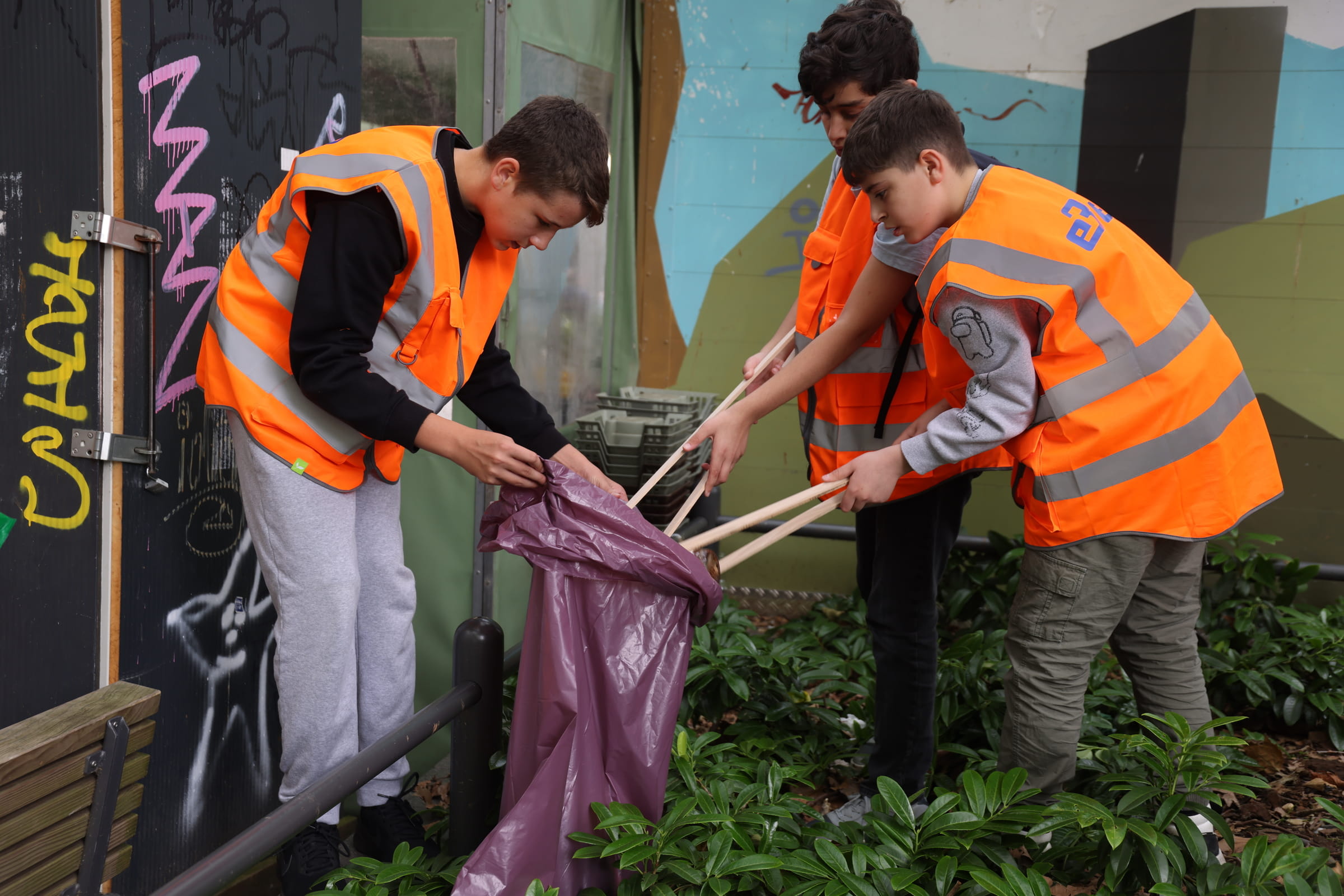 Drei Jungs stecken Müll in einen Müllbeutel (Quelle: Ludwig Grunewald)
