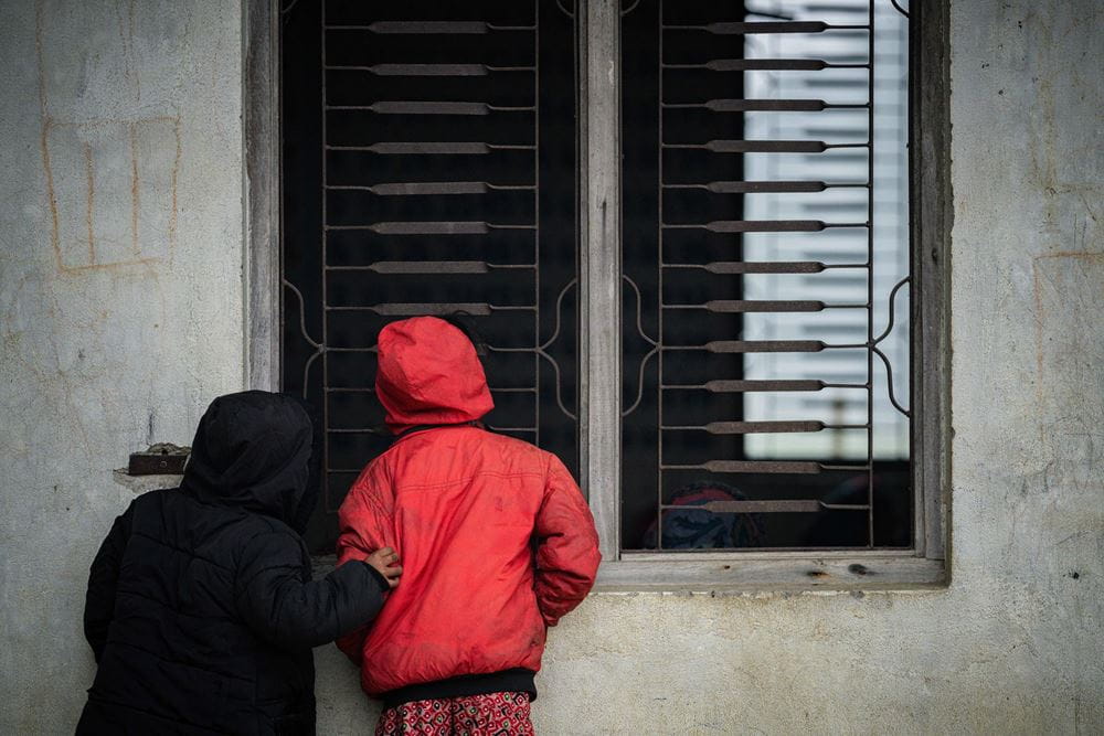 Zwei Kinder sind von hinten zu sehen und schauen durch ein Fenster nach drinnen Foto : Jakob Studnar /  Kindernothilfe. Zwei Kinder sind von hinten zu sehen und schauen durch ein Fenster nach drinnen Foto : Jakob Studnar /  Kindernothilfe.