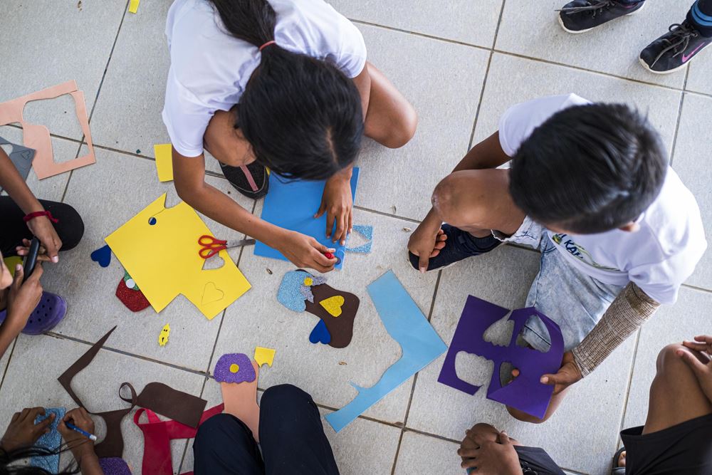 Kinder basteln auf dem Boden (Quelle: Kindernothilfe) Kinder basteln auf dem Boden (Quelle: Kindernothilfe)
