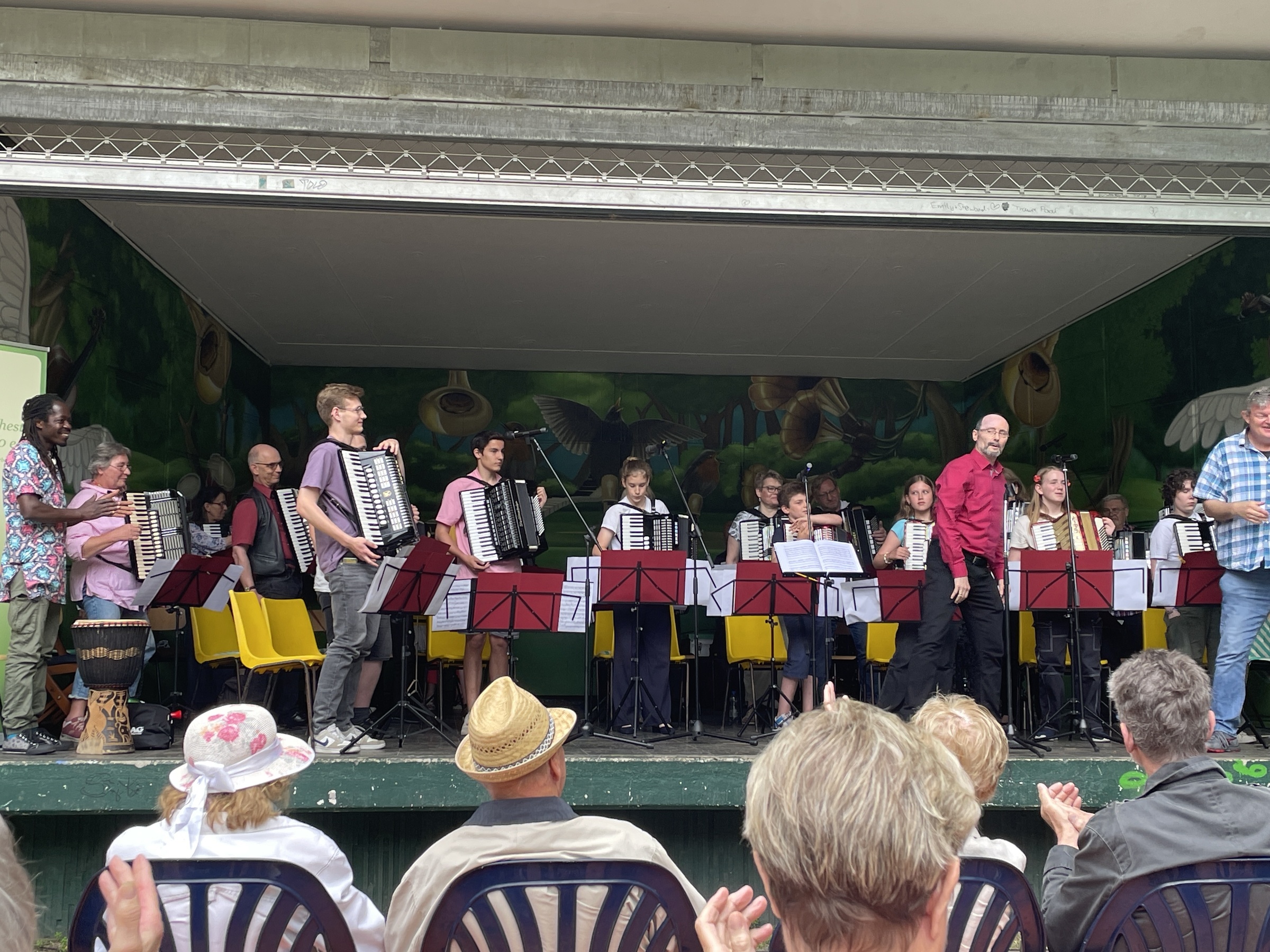 Ein Akkordeonorchester auf einer Bühne, im Vordergrund Zuschauer (Quelle: privat) Ein Akkordeonorchester auf einer Bühne, im Vordergrund Zuschauer (Quelle: privat)