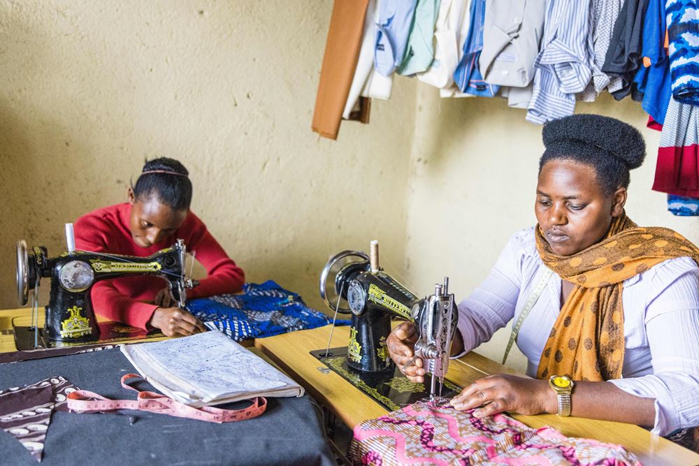 Zwei Frauen sitzen vor ihren Nähmaschinen und nähen Kleidung (Foto: Martin Bondzio/Kindernothilfe) Zwei Frauen sitzen vor ihren Nähmaschinen und nähen Kleidung (Foto: Martin Bondzio/Kindernothilfe)