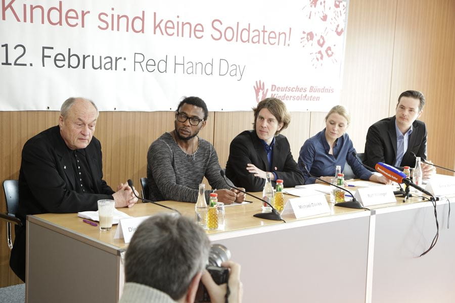 Dietrich Mattausch, Michael Davies, Ralf Willinger, Antje Weber, Christian Kage (Quelle: Kindernothilfe) Dietrich Mattausch steht an einem Rednerpult und liest einen Printbeitrag vor