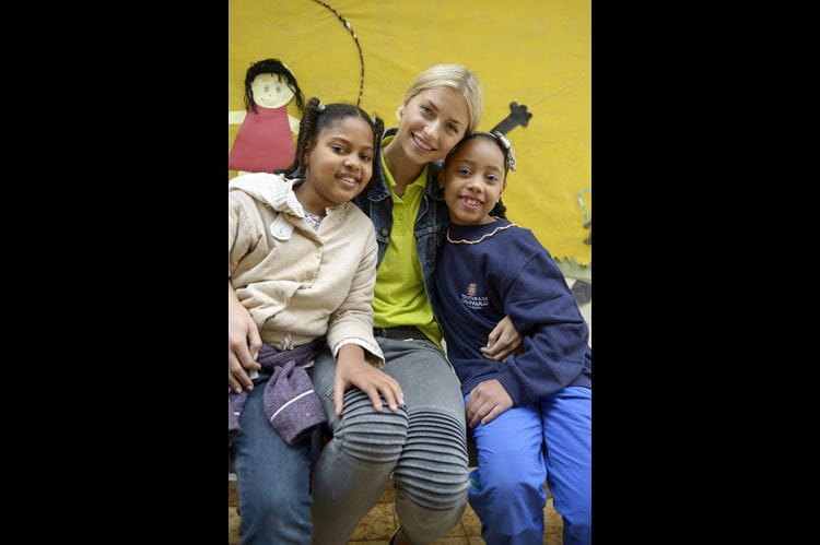 Lena Gercke in Brasilien zwischen zwei Mädchen, alle drei lächeln in die Kamera Foto: Florian Kopp / Kindernothilfe Botschafterin Lena Gercke bei einer Kindernothilfe-Reise