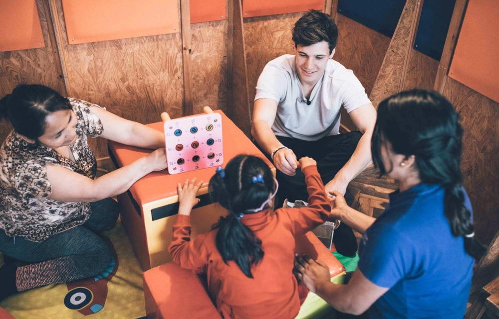 Wincent Weiss in Peru, spielt mit einem Mädchen und zwei Frauen (Quelle: Kindernothilfe) Wincent Weiss sitzt in einer wirtschaftlich armen Siedlung in den Bergen von Peru