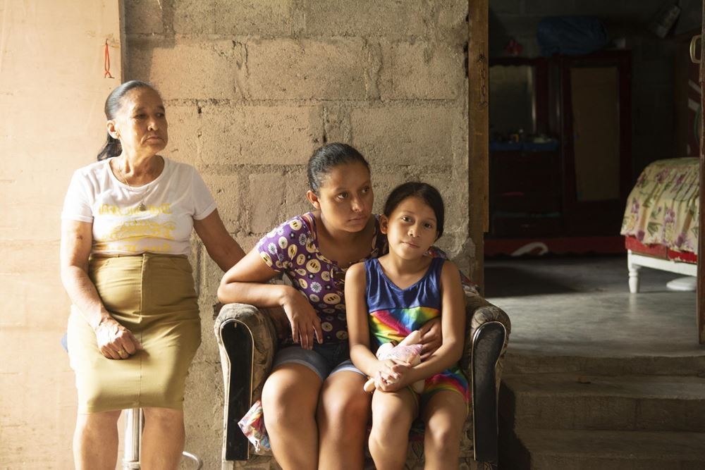 Eine Mutter sitzt mit ihrer Tochter gemeinsam auf einem Sessel in Bordos, Honduras. Die Grossmutter steht daneben (Quelle: Christian Nusch/Victor Zavaleta Carbajal) Eine Mutter sitzt mit ihrer Tochter gemeinsam auf einem Sessel in Bordos, Honduras. Die Grossmutter steht daneben (Quelle: Christian Nusch/Victor Zavaleta Carbajal)