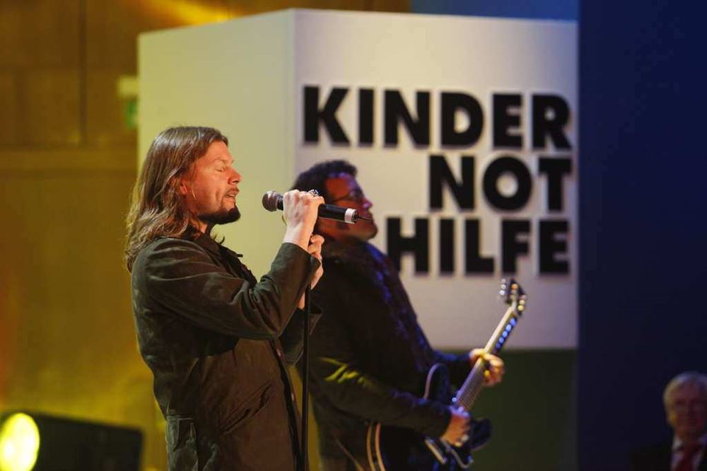 Rea Garvey singt vor einem Schild der Kindernothilfe (Quelle: Kindernothilfe) Rea Garvey singt