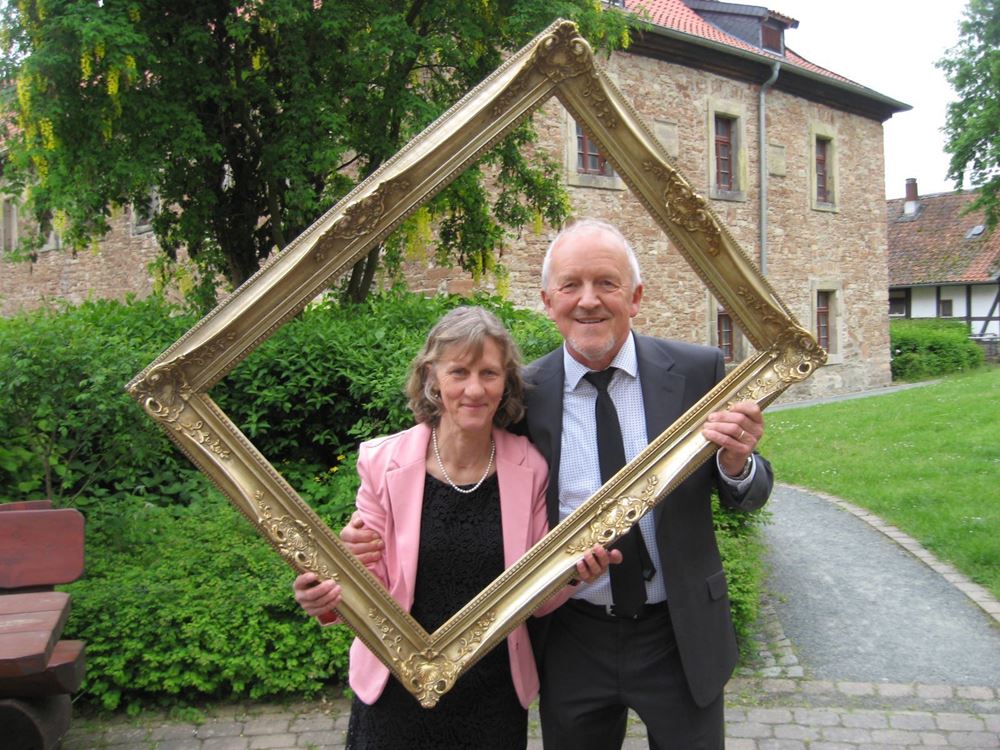 Ein Ehepaar blickt durch einen goldenen Bilderrahmen Ein Ehepaar blickt durch einen goldenen Bilderrahmen