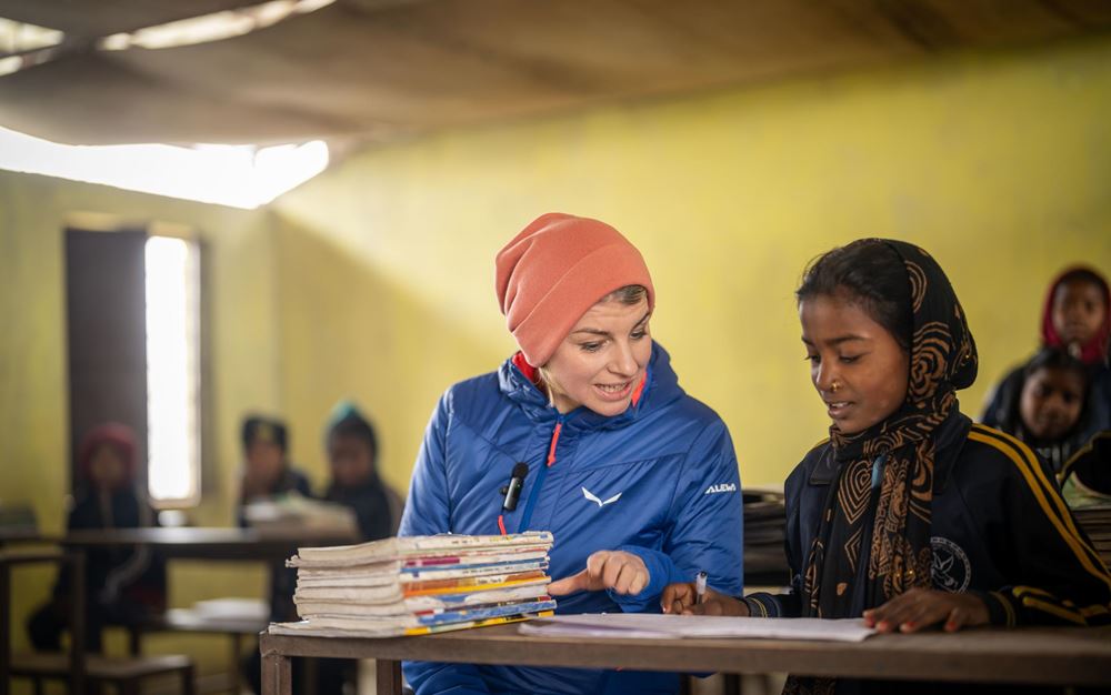 Sabine Heinrich sitzt neben einer Schülerin auf der Schulbank und schaut sich ihr Heft an (Quelle: Jakob Studnar) Sabine Heinrich sitzt neben einer Schülerin auf der Schulbank und schaut sich ihr Heft an (Quelle: Jakob Studnar)