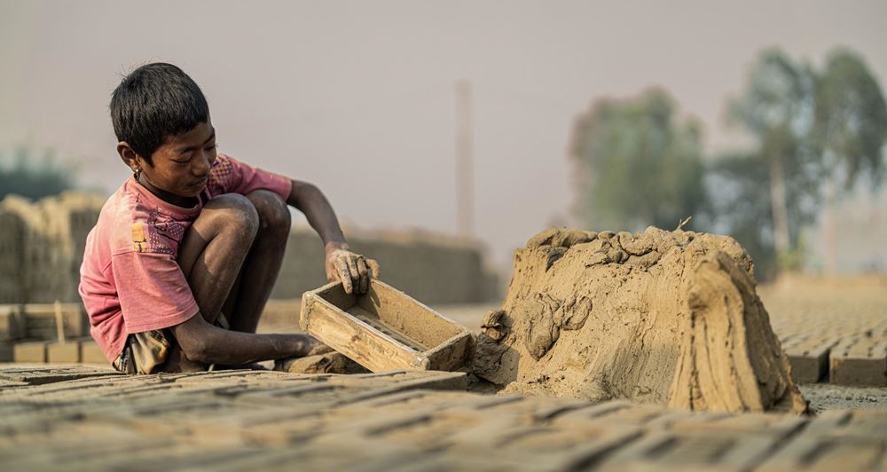 Ein Junge füllt eine Holzform mit Lehm (Quelle: Jakob Studnar) Ein Junge füllt eine Holzform mit Lehm (Quelle: Jakob Studnar)