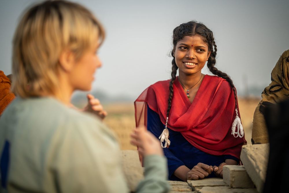 Sabine Heinrich spricht mit einem Mädchen mit langen Zöpfen und rotem Tuch (Quelle: Jakob Studnar) Sabine Heinrich spricht mit einem Mädchen mit langen Zöpfen und rotem Tuch (Quelle: Jakob Studnar)