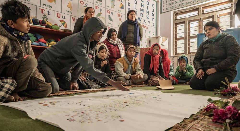 Eine Gruppe von Kindern und Jugendlichen sitzt um einen gemalten Stadtplan herum (Quelle: Jakob Studnar) Eine Gruppe von Kindern und Jugendlichen sitzt um einen gemalten Stadtplan herum (Quelle: Jakob Studnar)
