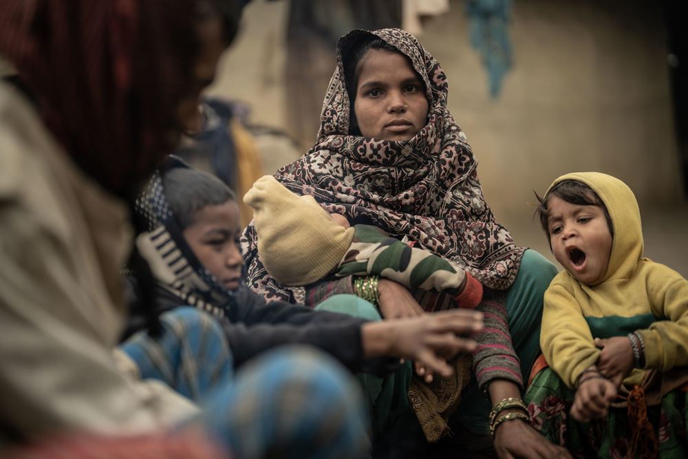 Eine junge Frau mit einem Baby im Arm, zwei Kinder sitzen rechts und links neben ihr (Quelle: Jakob Studnar) Eine junge Frau mit einem Baby im Arm, zwei Kinder sitzen rechts und links neben ihr (Quelle: Jakob Studnar)