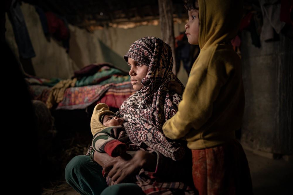 Eine Mutter sitzt mit zwei Kindern in einer dunklen, ärmlichen Hütte (Quelle: Jakob Studnar) Eine Mutter sitzt mit zwei Kindern in einer dunklen, ärmlichen Hütte (Quelle: Jakob Studnar)