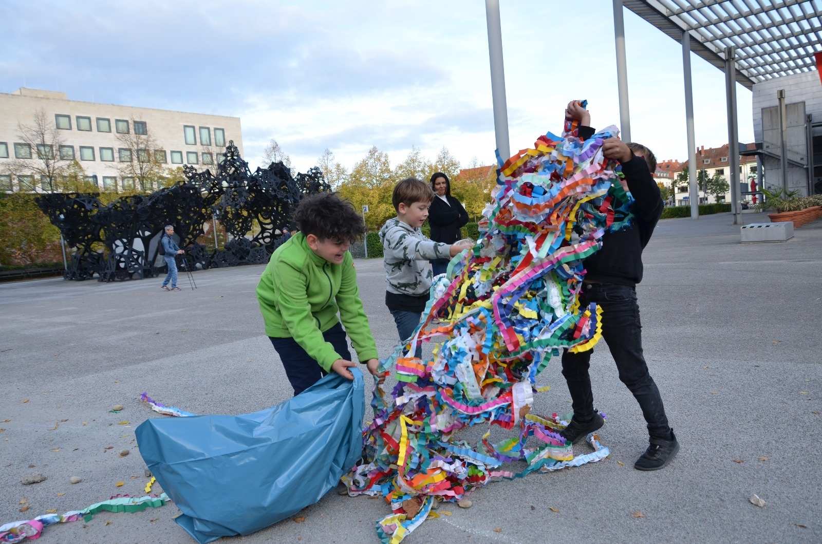 Einige Jungen ziehen eine große Menge Papierschlangen aus einem blauen Müllsack (Quelle: privat)