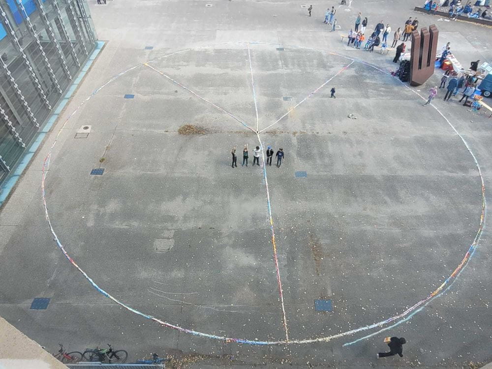 5 Jungen stehen auf dem Schulhof in einem riesigen Peace-Zeichen aus Papierschlangen (Quelle: privat) 5 Jungen stehen auf dem Schulhof in einem riesigen Peace-Zeichen aus Papierschlangen (Quelle: privat)