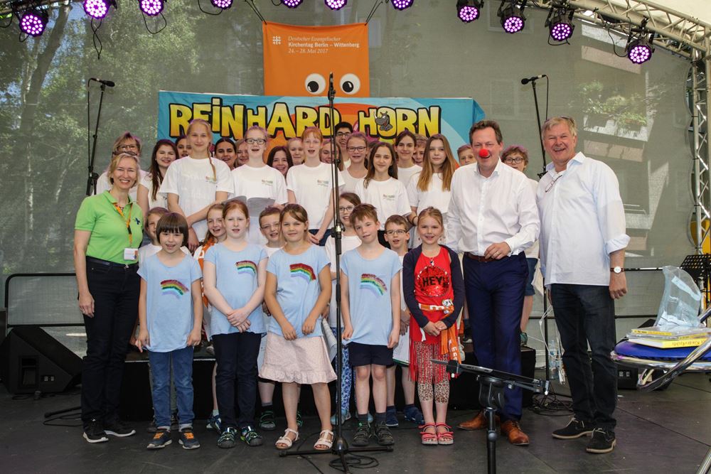 Reinhard Horn mit einer Kindergruppe auf einer Bühne beim  Kirchentag in Berlin (Quelle: Christian Herrmanny) Reinhard Horn mit einer Kindergruppe auf einer Bühne beim  Kirchentag in Berlin (Quelle: Christian Herrmanny)