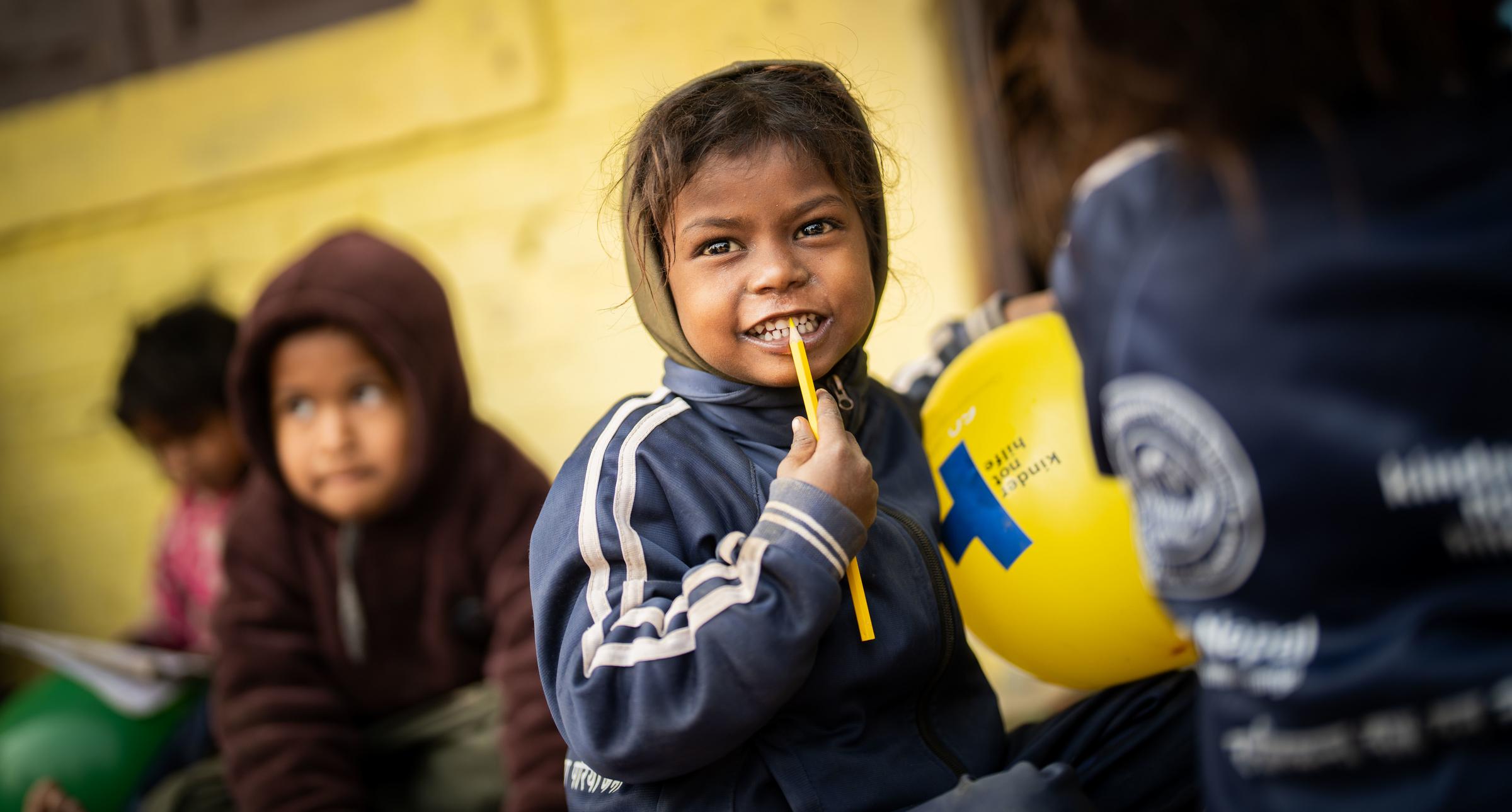 Mädchen mit Kindernothilfe Luftballon in der Hand lächelt. Foto : Jakob Studnar / Kindernothilfe. Mädchen mit Kindernothilfe Luftballon in der Hand lächelt. Foto : Jakob Studnar / Kindernothilfe.