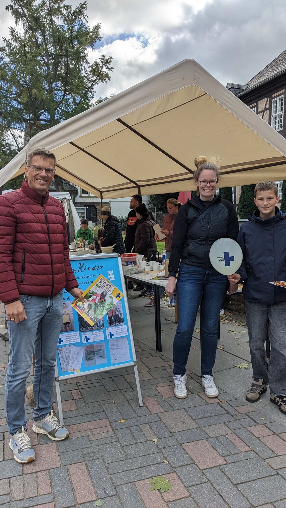 Eine dreiköpfige Familie steht vor einem selbst gemalten Plakat (Quelle: privat) Eine dreiköpfige Familie steht vor einem selbst gemalten Plakat (Quelle: privat)