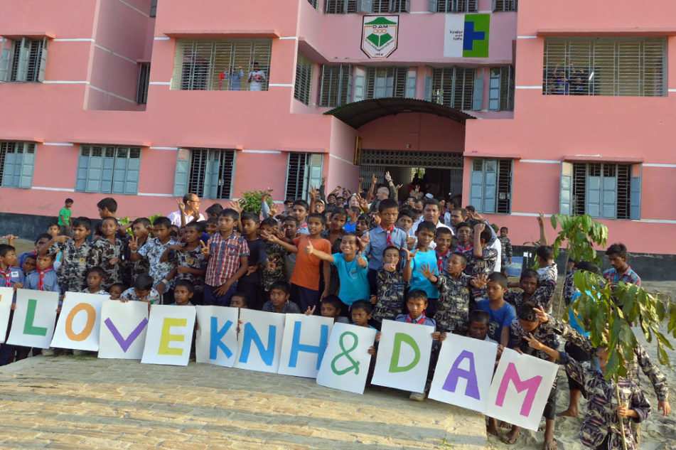 Große Gruppe Kinder vor der Kinderstadt mit Plakat "I love KNH &DAM" (Quelle: Kindernothilfe) Große Gruppe Kinder vor der Kinderstadt mit Plakat "I love KNH &DAM" (Quelle: Kindernothilfe)