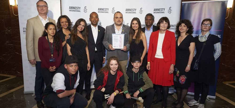 VLNR: Hinrich Westerkamp, Berta Zuniga Caceres, Najia Bounaim, Ferhan Önder, Markus N. Beeko, Taher Mokhtar, Ferzan Önder, Salil Shetty, Jutta Klöwer, Aniko Bakonyi, Anne Tismer, davor Musiker von BÄM! bei der Verleihung des Amnesty Menschenrechtspreis am 16042018 in Berlin. (Quelle: Henning Schacht) VLNR: Hinrich Westerkamp, Berta Zuniga Caceres, Najia Bounaim, Ferhan Önder, Markus N. Beeko, Taher Mokhtar, Ferzan Önder, Salil Shetty, Jutta Klöwer, Aniko Bakonyi, Anne Tismer, davor Musiker von BÄM! bei der Verleihung des Amnesty Menschenrechtspreis am 16042018 in Berlin. (Quelle: Henning Schacht)