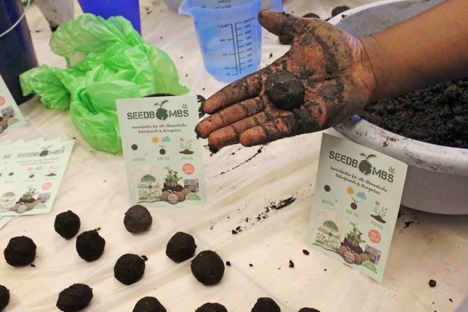 Die Gebrauchsanweisung der Samenbomben neben einer Hand voll Erde (Quelle: Kindernothilfe) Die Gebrauchsanweisung der Samenbomben neben einer Hand voll Erde (Quelle: Kindernothilfe)