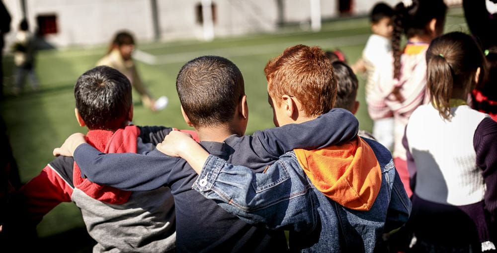 Kinder von hinten auf einer Wiese zu Kinderrechten Kinder von hinten auf einer Wiese zu Kinderrechten