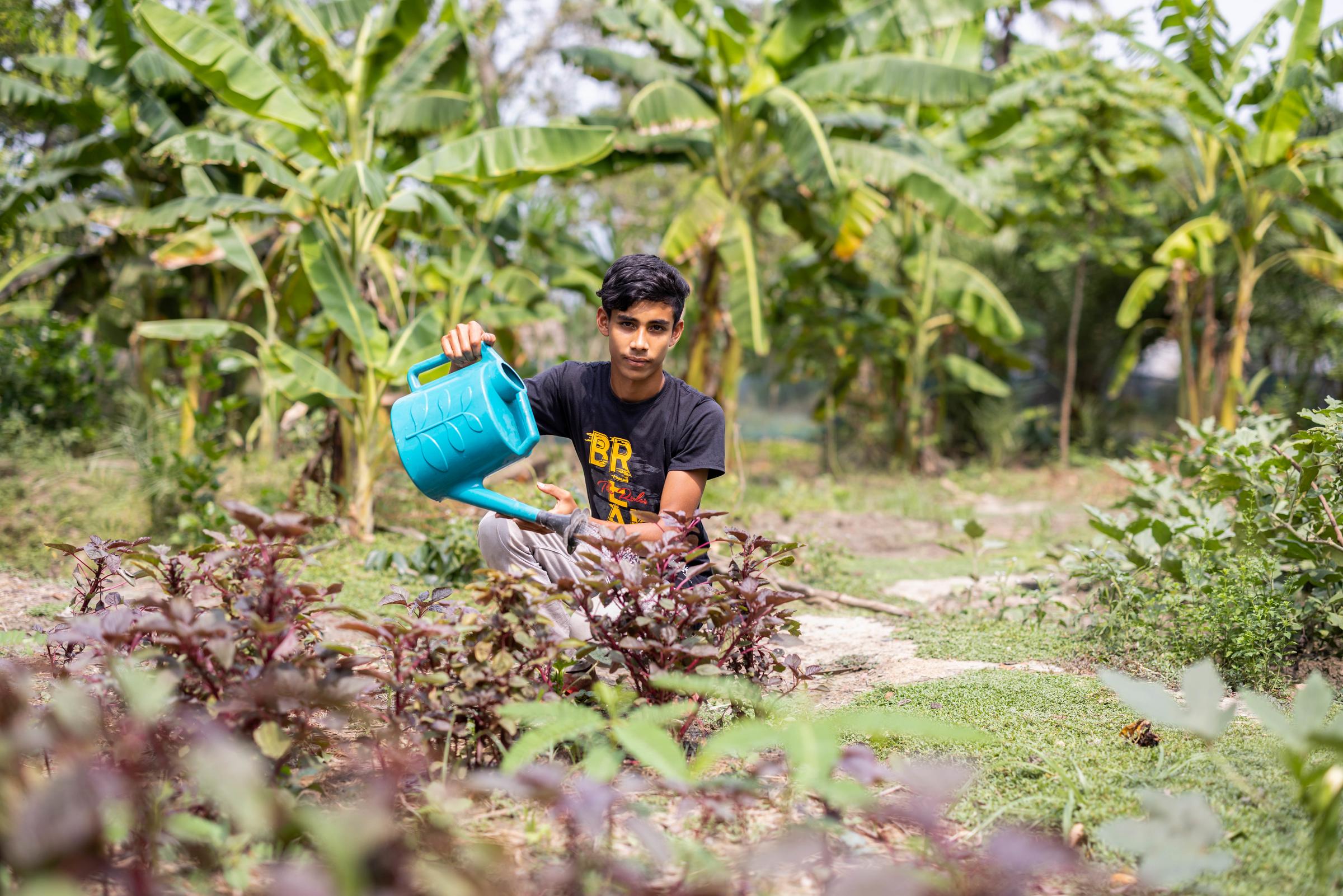 Junge gießt eine Pflanze in Bangladesch (Quelle: Jakob Studnar)