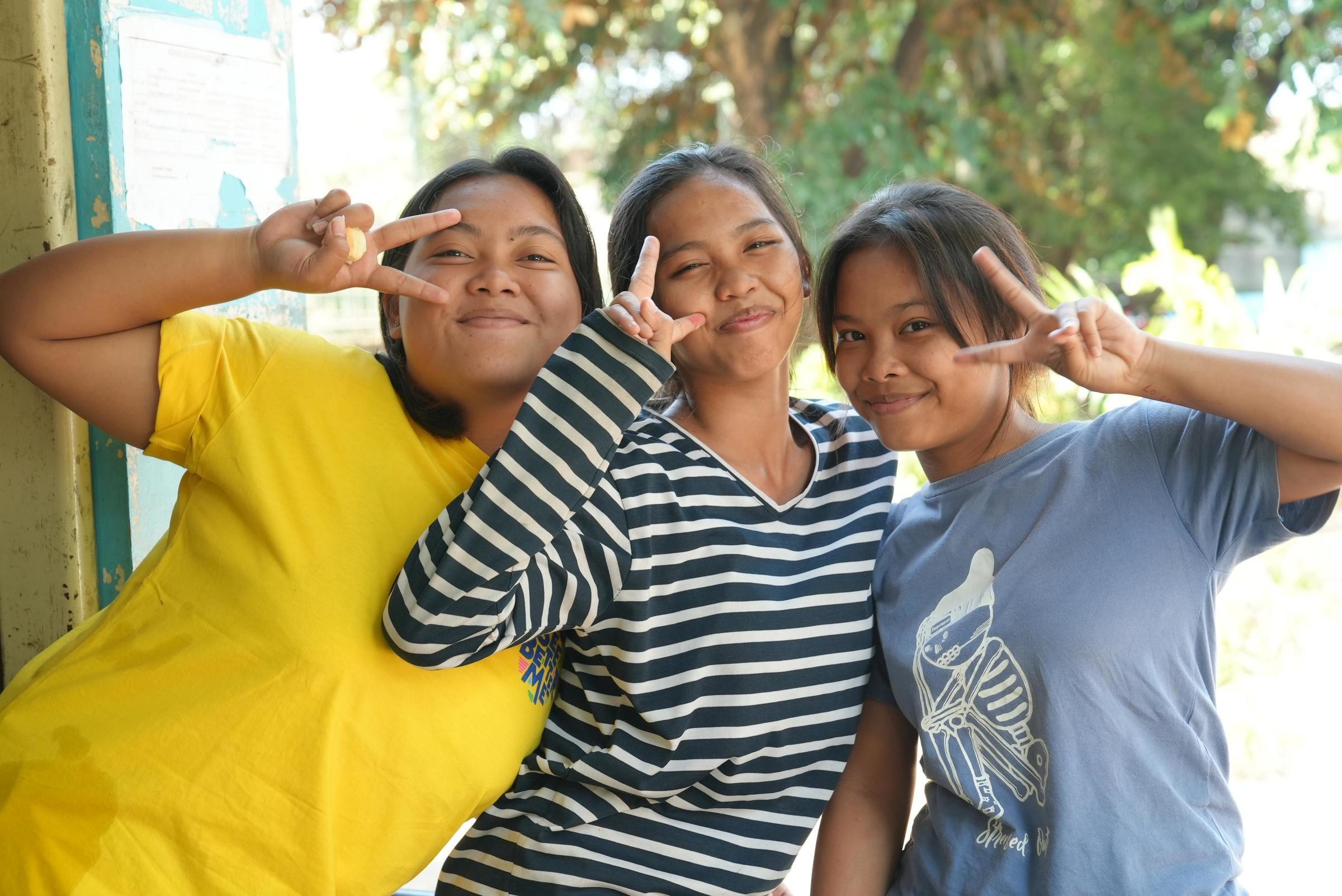 Drei Mädchen in Indonesien lachen und zeigen das Peace-Zeichen. (Foto: Jonas Hieronimus)