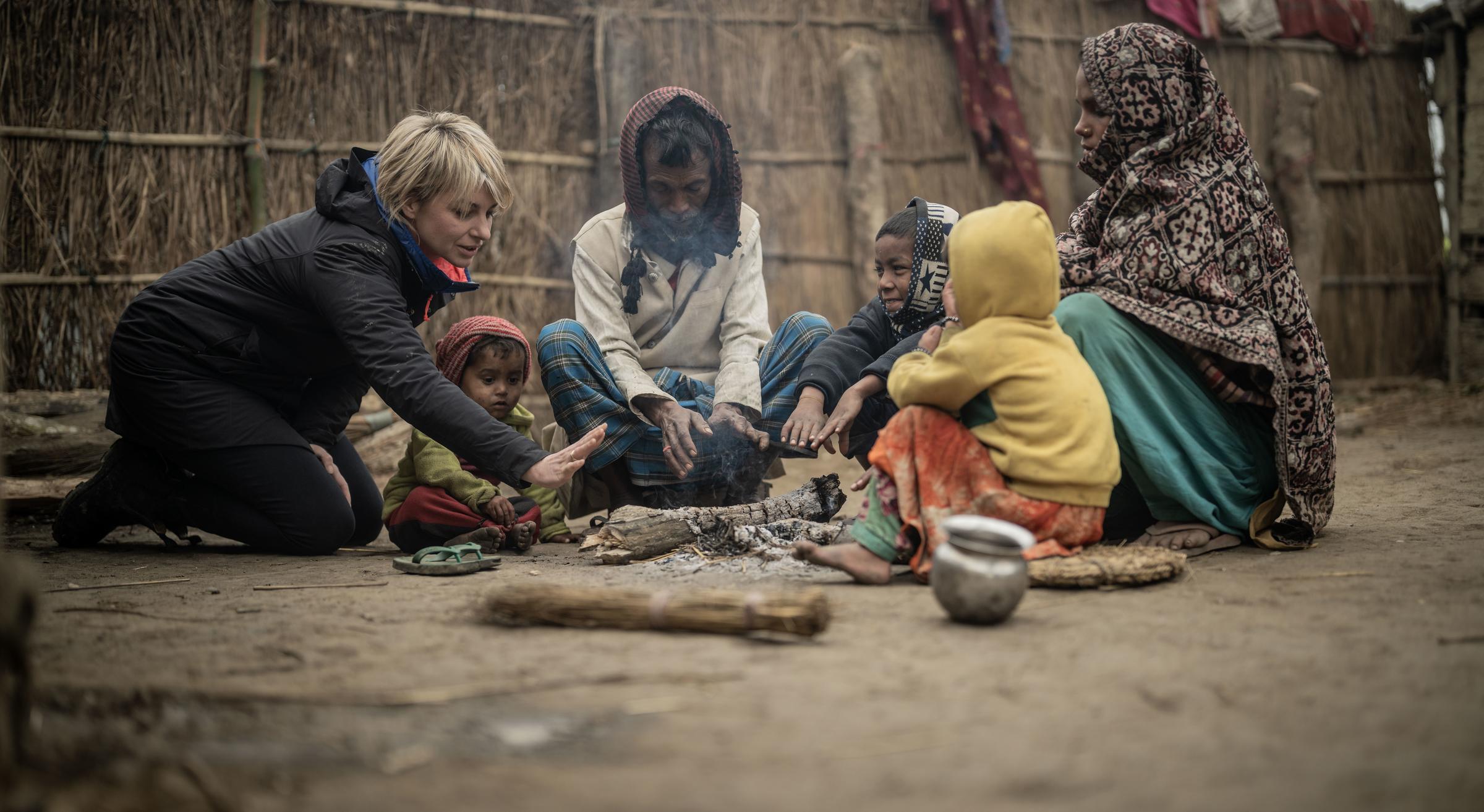 Sabine Heinrich sitzt mit einer Familie zusammen in Nepal (Foto : Jakob Studnar / Kindernothilfe)