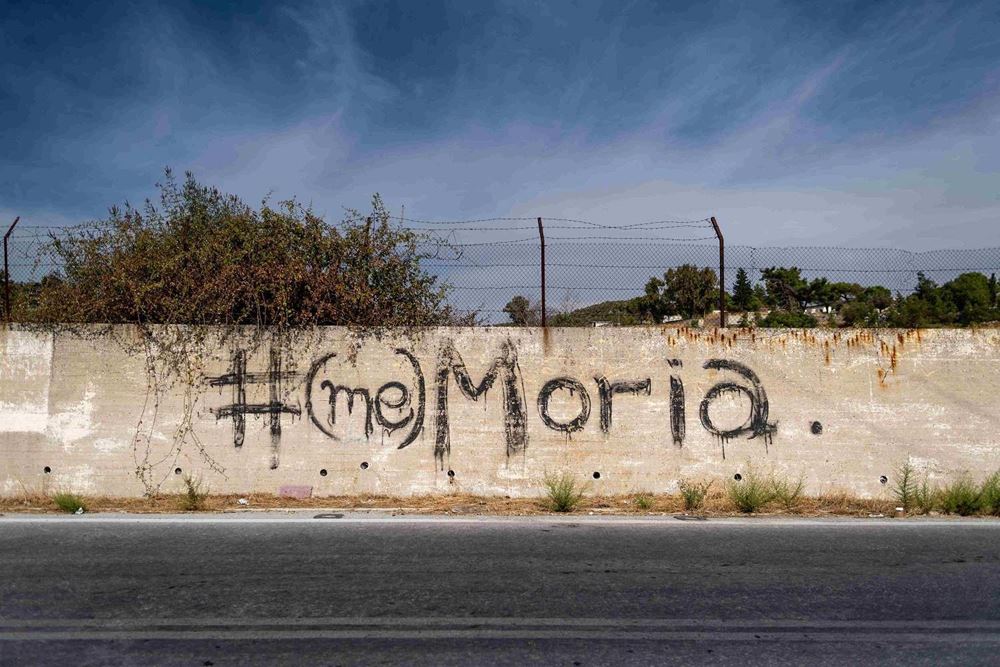 Mauer des ehemaligen Moria-Lagers mit dem Schriftzug #(me)Moria (Quelle: Lars Heidrich) Mauer des ehemaligen Moria-Lagers mit dem Schriftzug #(me)Moria (Quelle: Lars Heidrich)