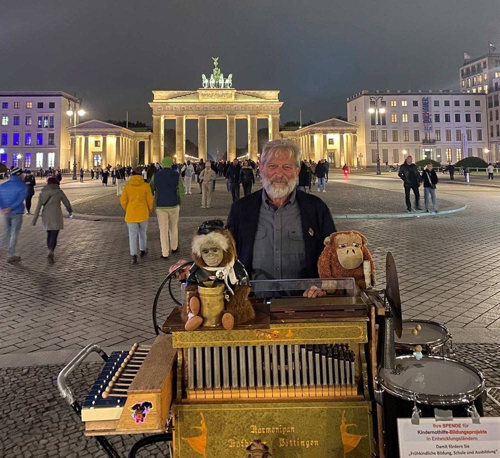 Ein Drehorgelspieler abends vor dem hell erleuchteten Brandenburger (Quelle: privat) Ein Drehorgelspieler abends vor dem hell erleuchteten Brandenburger (Quelle: privat)